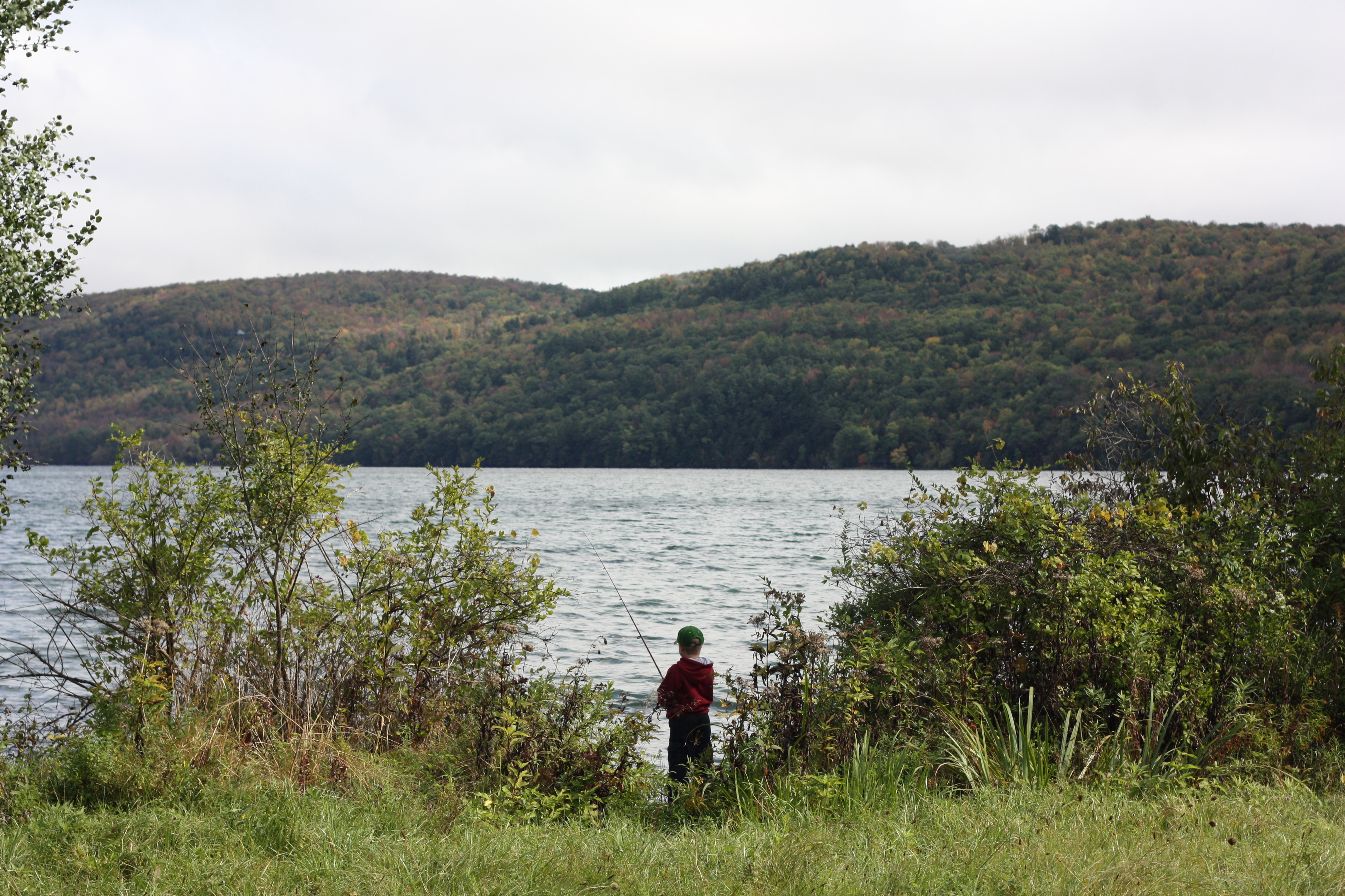 child fishing by a lake