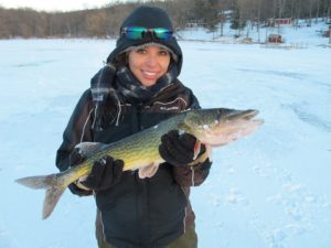 woman holding fish on frozen lake