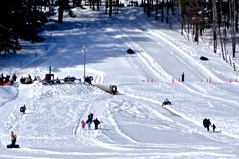 people tubing down a snowy hill at Glimmerglass State Park