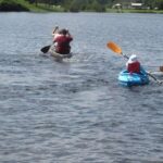 Five kayakers paddle on a Lake