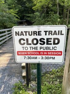 Sign stating trail is closed during school hours