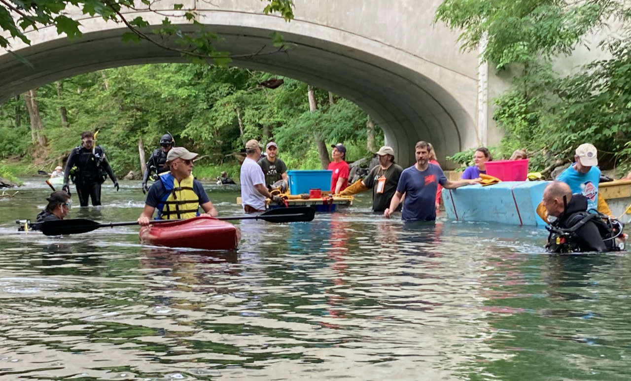 people in kayaks, others in wetsuits in the Susquehanna River