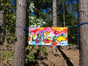 Artwork hanging between two trees at Texas School House State Forest, On the Trail of Art 2021.