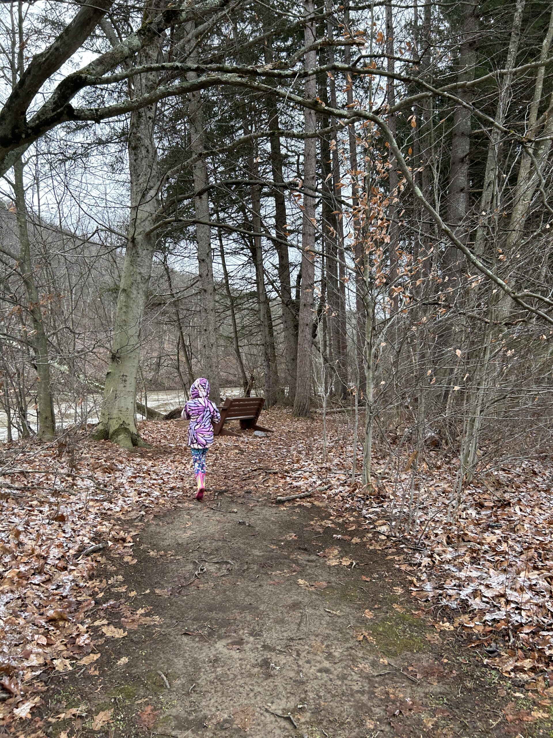 girl walking on a trail by a river