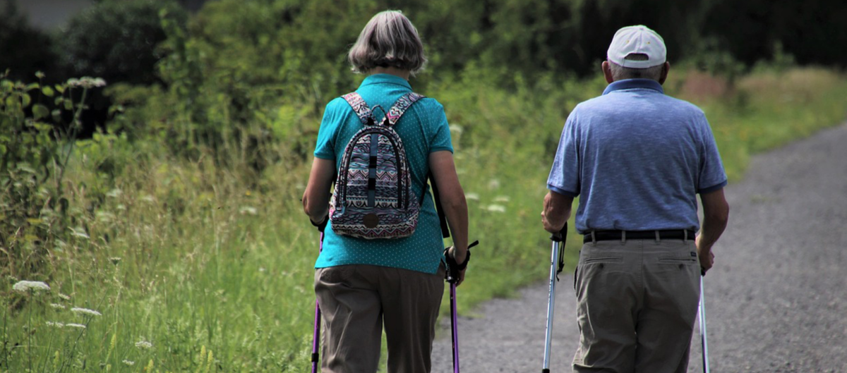 two people walking on a path outside