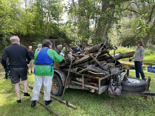 two people stand by a trash pile