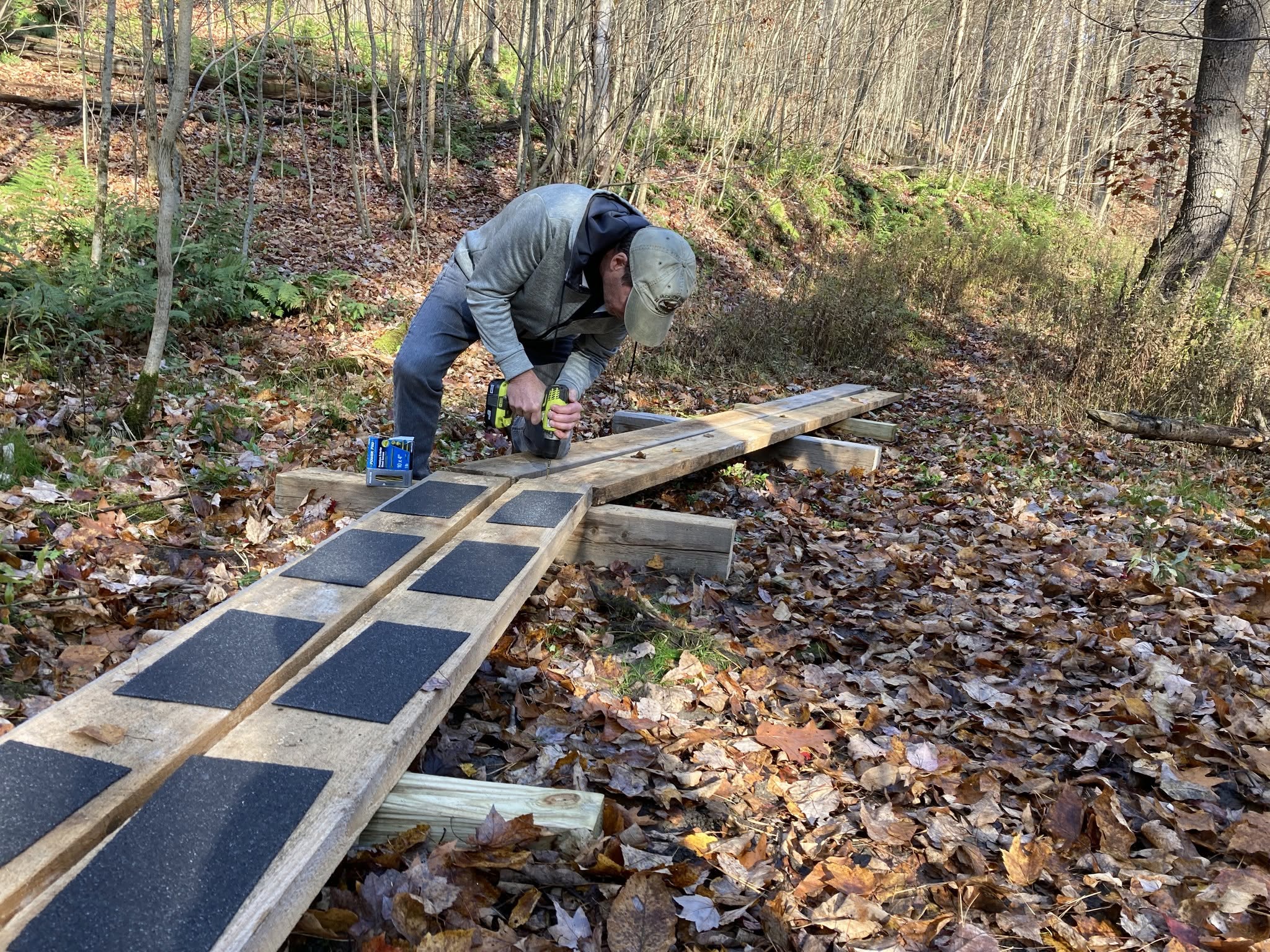 a volunteer is working on an elevated wooden pathway